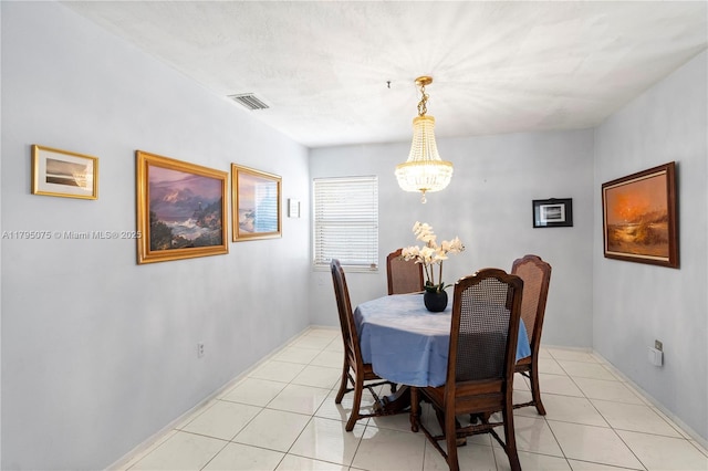 dining space with visible vents, a notable chandelier, and light tile patterned flooring
