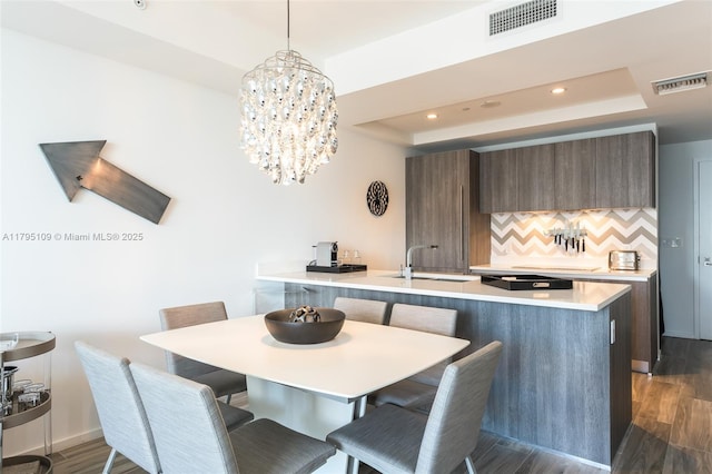 dining area featuring recessed lighting, a raised ceiling, dark wood-style floors, and visible vents