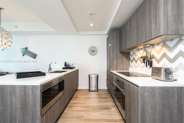 kitchen with a sink, light wood finished floors, modern cabinets, and stainless steel appliances