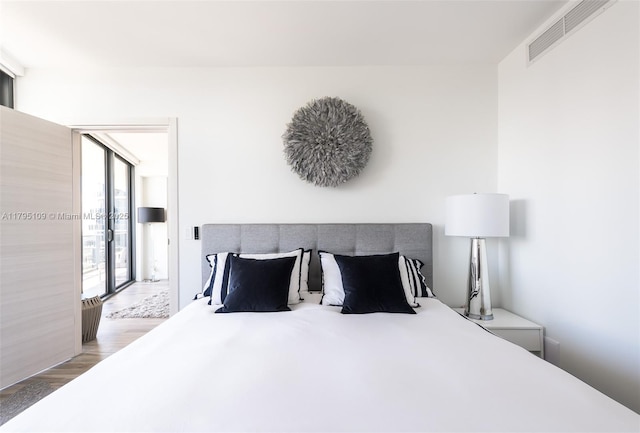bedroom with visible vents and wood finished floors