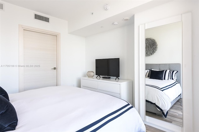 bedroom featuring wood finished floors and visible vents