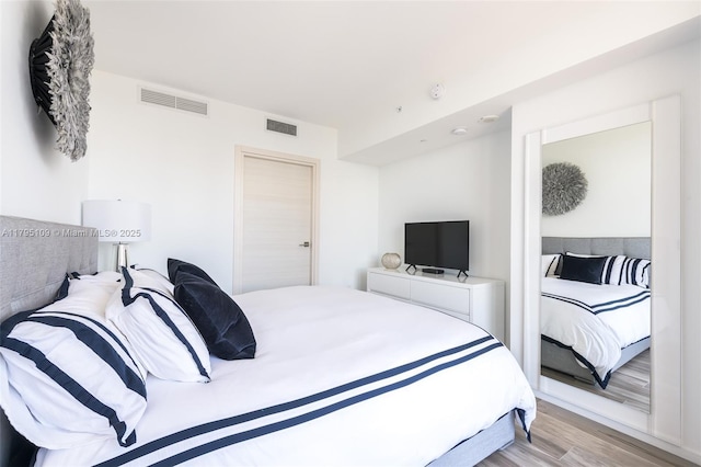 bedroom with visible vents and light wood-style flooring