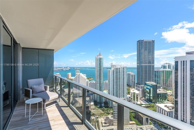 balcony featuring a water view and a city view