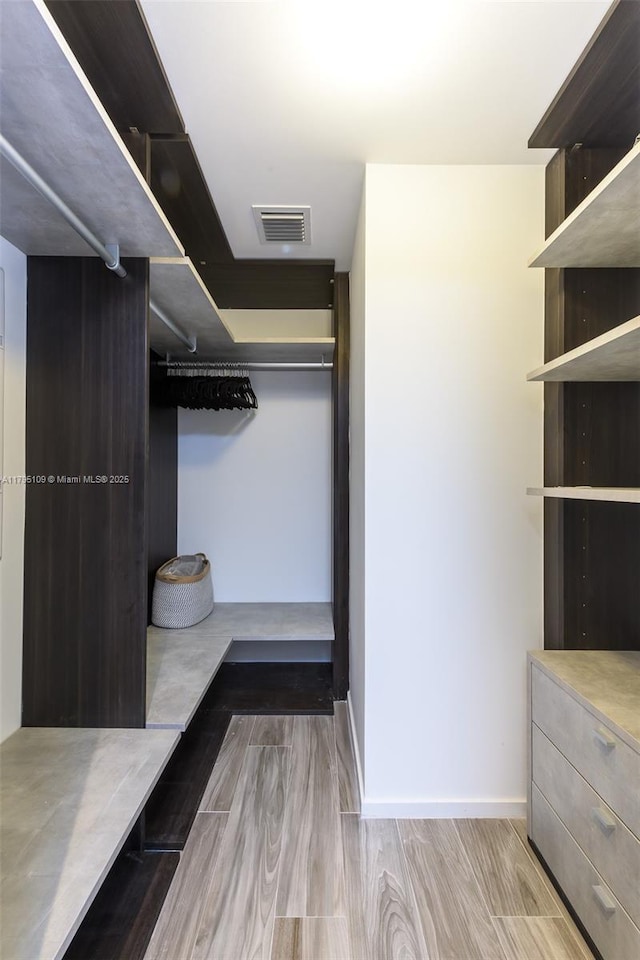 walk in closet with wood finished floors and visible vents