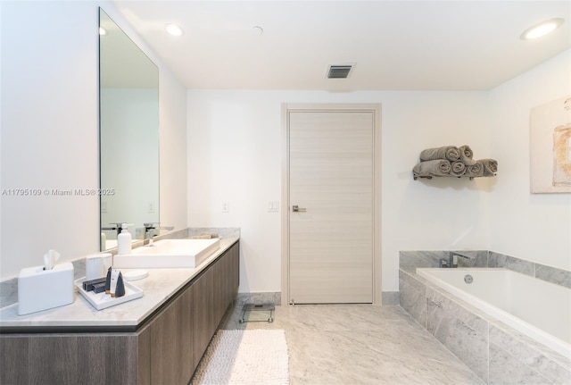 bathroom with recessed lighting, visible vents, a garden tub, and vanity