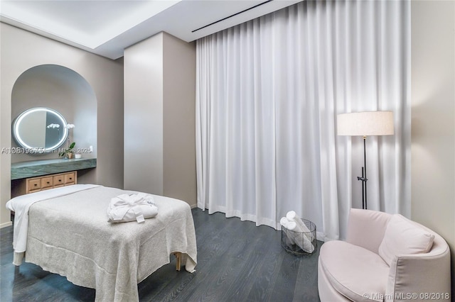 bedroom with dark wood-style flooring and baseboards