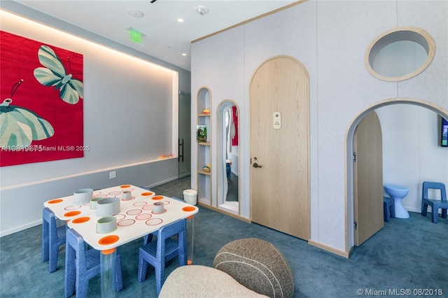 rec room with baseboards, arched walkways, and carpet flooring