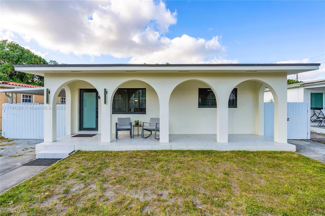 617 W 33rd St, Hialeah, FL 33012 - back of property featuring a porch, a yard, fence, and stucco siding