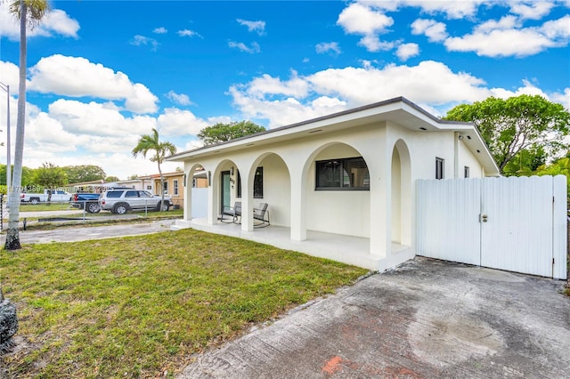 617 W 33rd St, Hialeah, FL 33012 - view of front of house with fence, covered porch, stucco siding, and a front yard