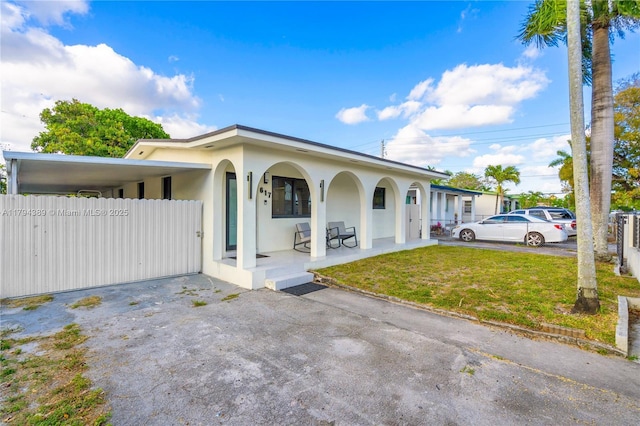 617 W 33rd St, Hialeah, FL 33012 - view of front of house featuring covered porch, fence, a front lawn, and stucco siding