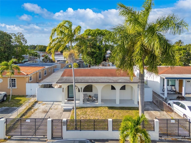 617 W 33rd St, Hialeah, FL 33012 - view of front of property featuring a porch, a gate, a fenced front yard, and stucco siding