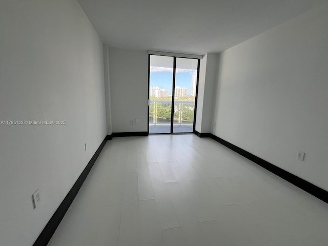 20515 E Country Club Dr Unit 649, Aventura, FL 33180 - spare room with baseboards and a wall of windows