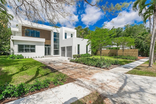 2730 SW 17th Ave, Miami, FL 33133 - view of front of home with a front lawn, stucco siding, fence, and concrete driveway