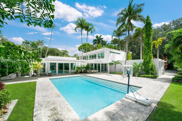 pool with a yard and a patio area