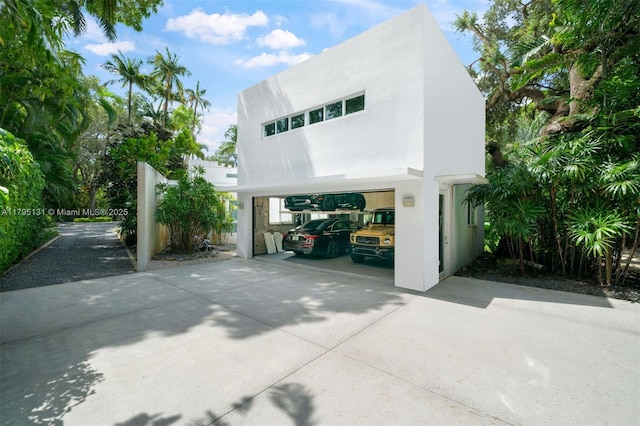 view of front of home featuring a garage, stucco siding, and concrete driveway
