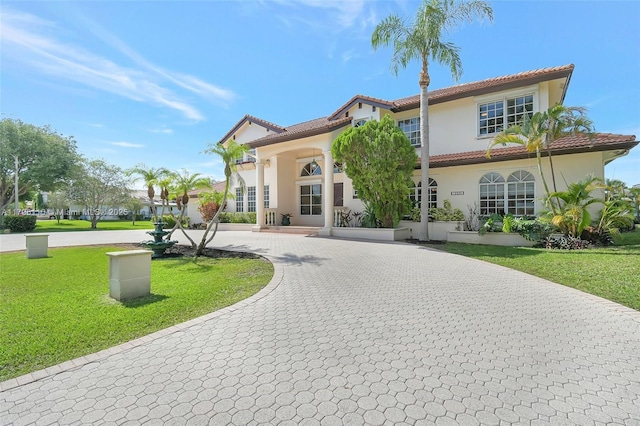 12360 SW 1st St, Plantation, FL 33325 - mediterranean / spanish-style house with a front lawn, stucco siding, a tile roof, and curved driveway