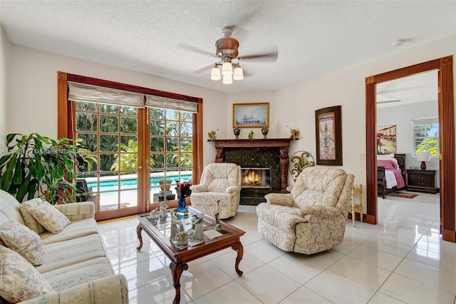 12360 SW 1st St, Plantation, FL 33325 - living room featuring ceiling fan, healthy amount of natural light, light tile patterned floors, a high end fireplace, and a textured ceiling