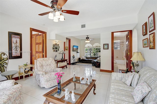 12360 SW 1st St, Plantation, FL 33325 - living room featuring a ceiling fan, light tile patterned flooring, a textured ceiling, and baseboards