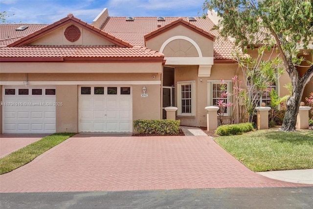9751 Malvern Dr, Tamarac, FL 33321 - view of front of property with a garage, a front yard, decorative driveway, stucco siding, and a tiled roof