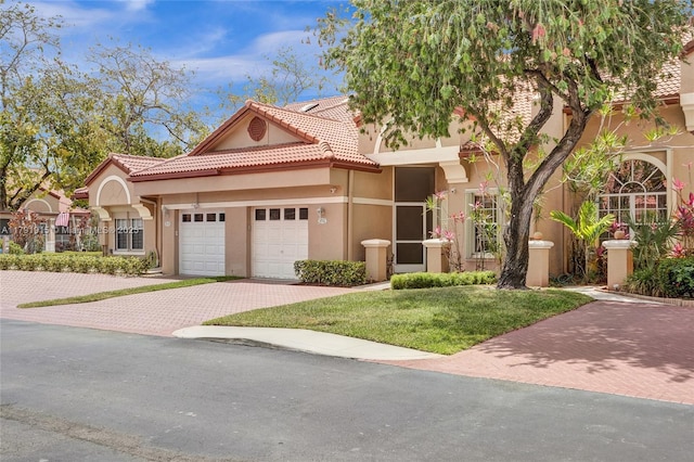 9751 Malvern Dr, Tamarac, FL 33321 - mediterranean / spanish house featuring an attached garage, stucco siding, a tile roof, a front lawn, and decorative driveway