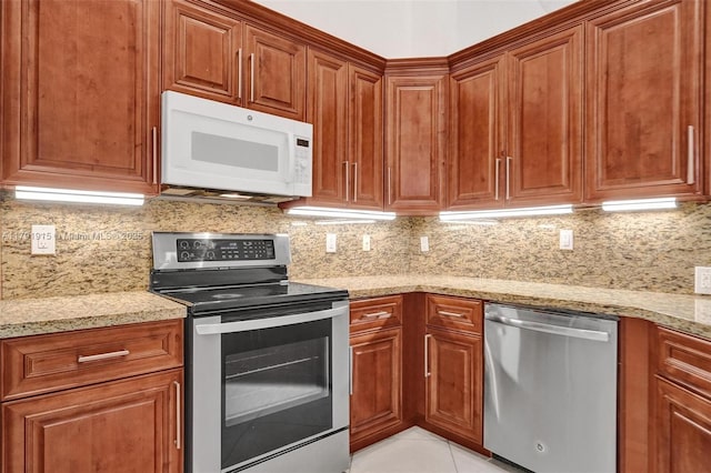 9751 Malvern Dr, Tamarac, FL 33321 - kitchen featuring light stone counters, brown cabinets, and stainless steel appliances