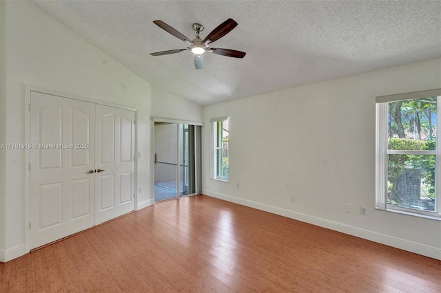 9751 Malvern Dr, Tamarac, FL 33321 - unfurnished bedroom featuring baseboards, a textured ceiling, wood finished floors, and multiple windows