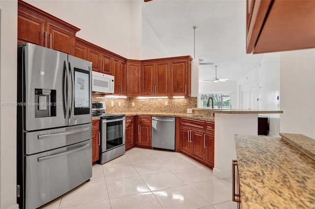 9751 Malvern Dr, Tamarac, FL 33321 - kitchen with a ceiling fan, light stone counters, a sink, decorative backsplash, and stainless steel appliances