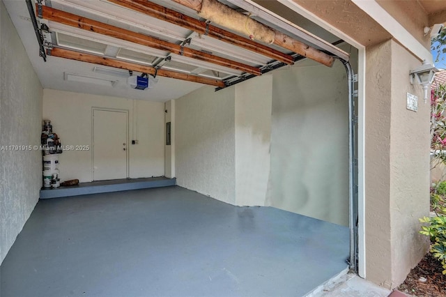 9751 Malvern Dr, Tamarac, FL 33321 - garage with secured water heater, a garage door opener, and a textured wall