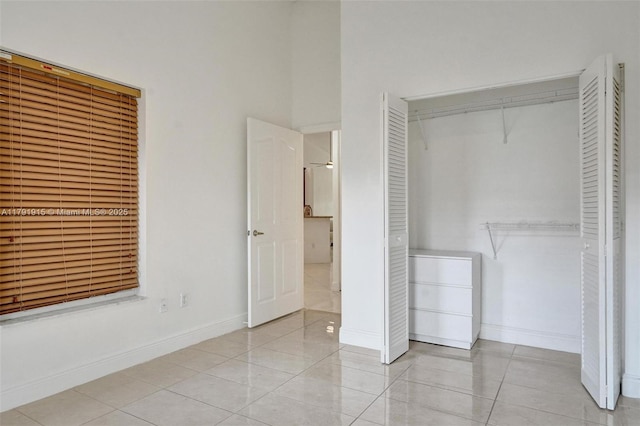 9751 Malvern Dr, Tamarac, FL 33321 - unfurnished bedroom with a closet, baseboards, a towering ceiling, and tile patterned flooring