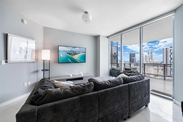 living area featuring light tile patterned flooring, baseboards, and a wall of windows