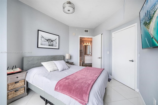 bedroom featuring baseboards, ensuite bathroom, light tile patterned flooring, and visible vents