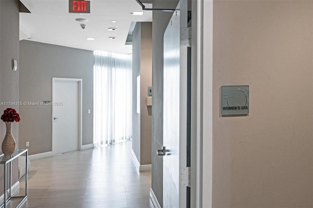 hallway featuring baseboards and wood finished floors