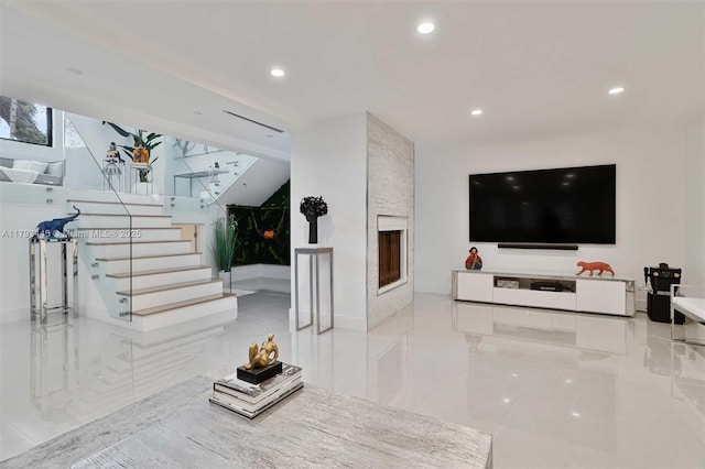 living room with recessed lighting, stairs, and a stone fireplace