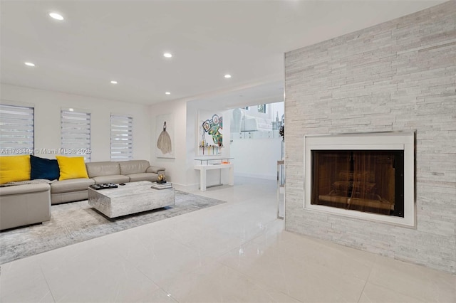 living room featuring recessed lighting, tile patterned floors, and a stone fireplace