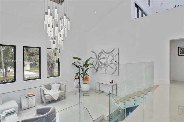 stairs with high vaulted ceiling, a notable chandelier, baseboards, and tile patterned floors