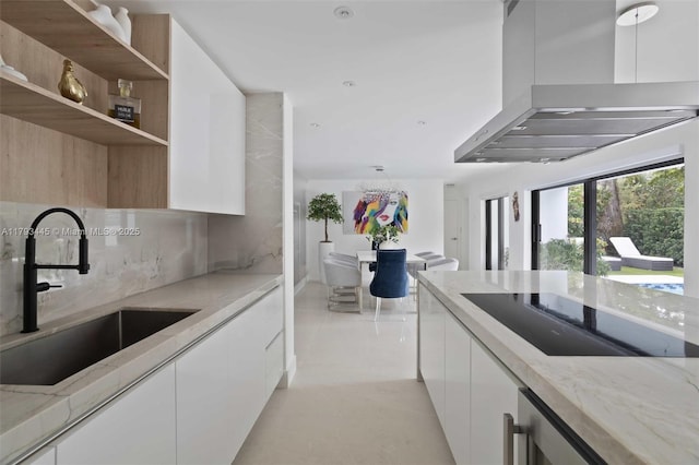 kitchen featuring wall chimney range hood, white cabinets, black electric stovetop, a sink, and modern cabinets