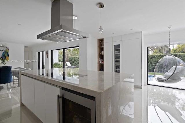 kitchen featuring island exhaust hood, a center island, modern cabinets, beverage cooler, and white cabinetry