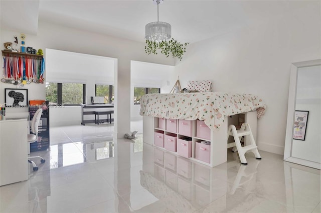 interior space featuring baseboards, an inviting chandelier, and tile patterned flooring