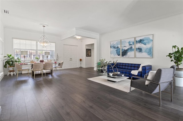 living area featuring visible vents, crown molding, a notable chandelier, and dark wood-style floors