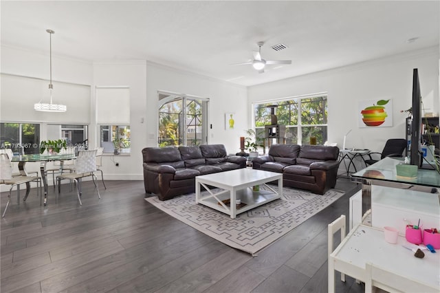 living room featuring visible vents, a ceiling fan, dark wood-style flooring, and a wealth of natural light
