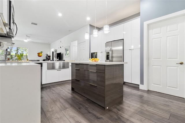 kitchen featuring stainless steel fridge, white cabinetry, and modern cabinets