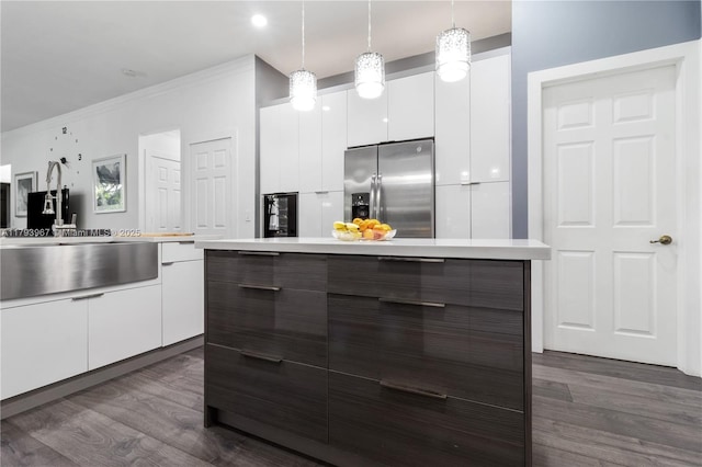 kitchen with stainless steel fridge, light countertops, modern cabinets, and dark wood-style flooring