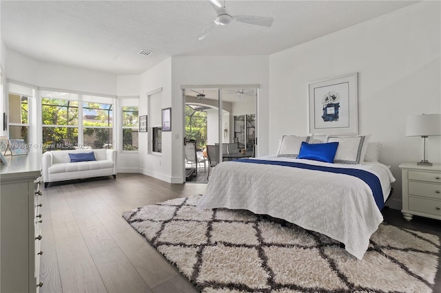 bedroom featuring access to outside, ceiling fan, wood-type flooring, baseboards, and visible vents