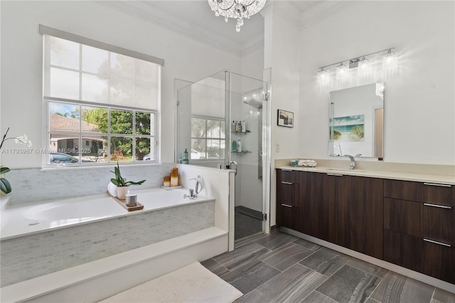 full bath featuring vanity, crown molding, a garden tub, a shower stall, and a notable chandelier