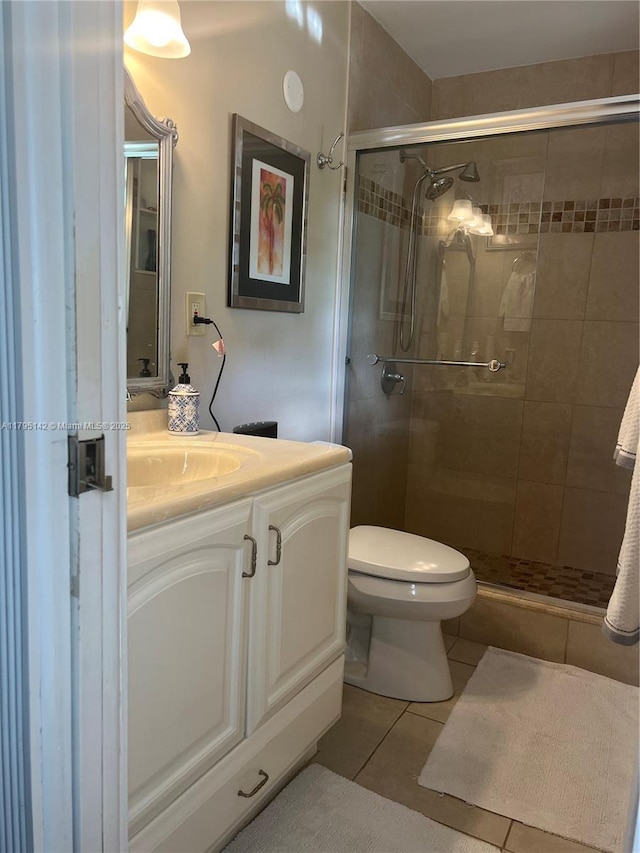 full bathroom with tile patterned flooring, a stall shower, toilet, and vanity