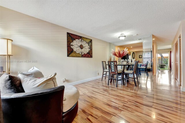 9829 Riverside Dr Unit 42-6, Coral Springs, FL 33071 - dining room featuring light wood-style floors, a textured ceiling, and baseboards