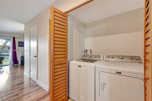 clothes washing area with laundry area, light wood finished floors, independent washer and dryer, and baseboards