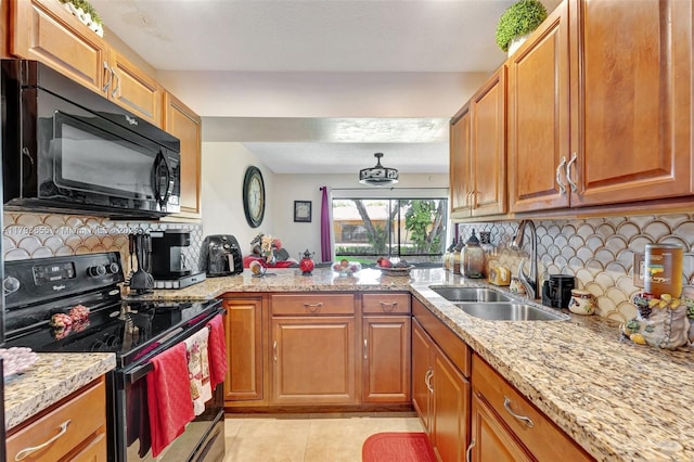 kitchen with decorative backsplash, range with electric stovetop, black microwave, light tile patterned floors, and a sink