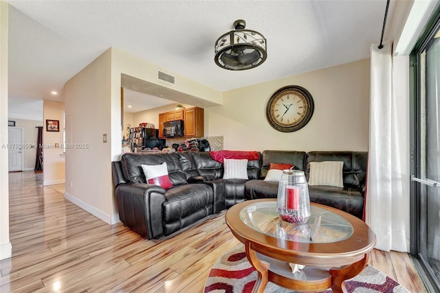 living area with light wood-type flooring, recessed lighting, baseboards, and visible vents