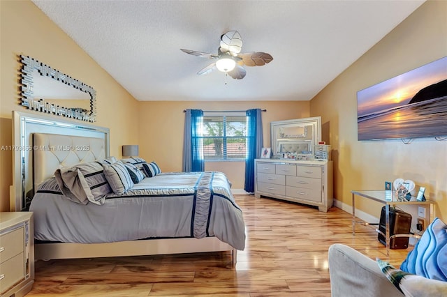 bedroom with baseboards, ceiling fan, a textured ceiling, and light wood-style flooring